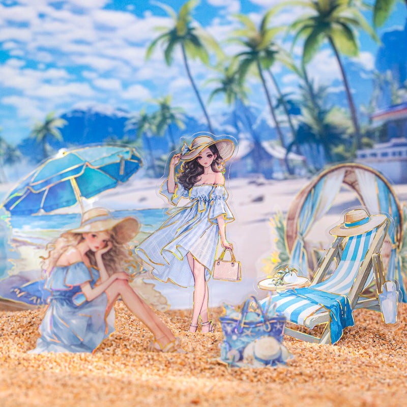StationeryHaul clear holographic stickers of women in blue dresses on a beach with palm trees and beach chairs.