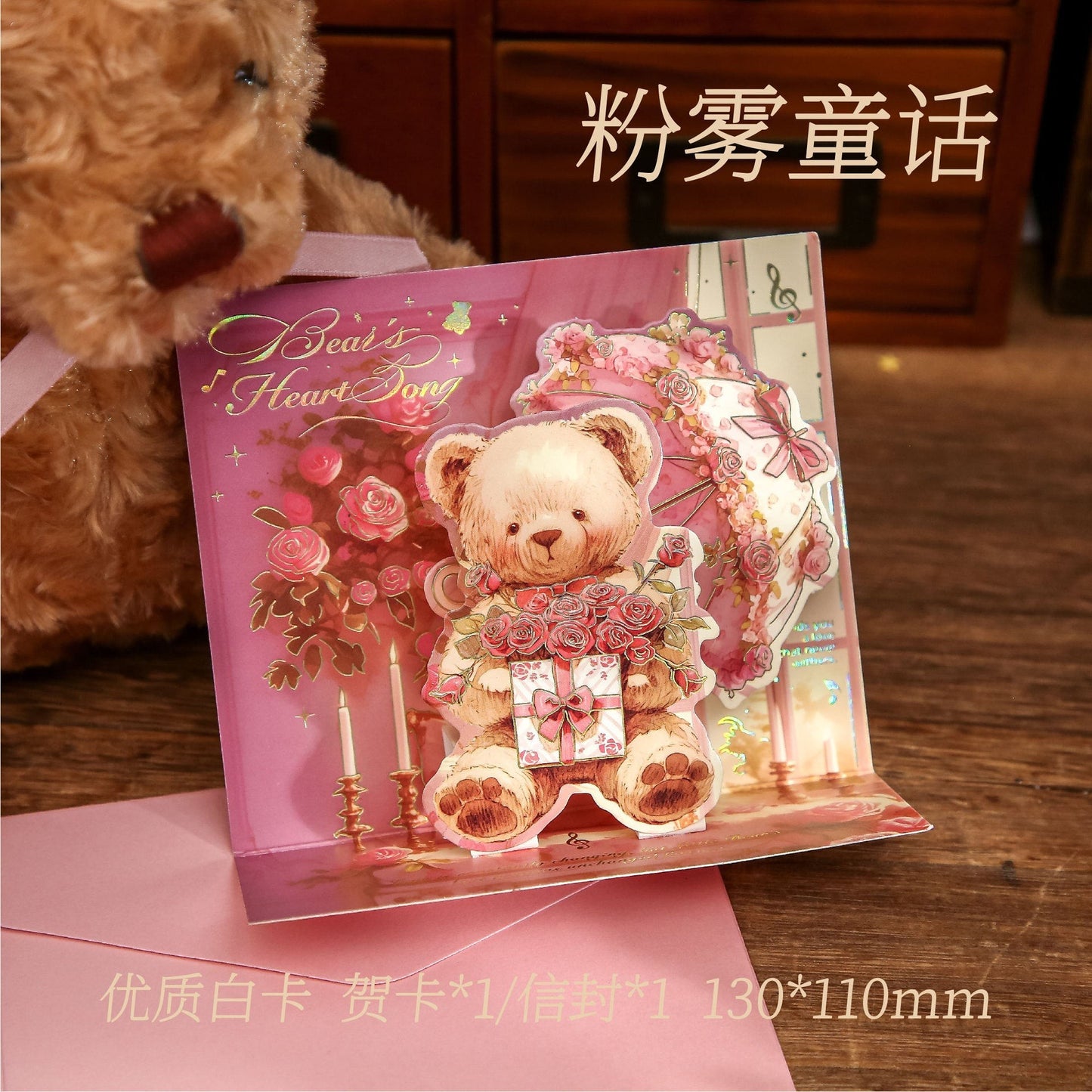 StationeryHaul pink pop-up card with a teddy bear holding roses and a gift, surrounded by candles and floral designs.