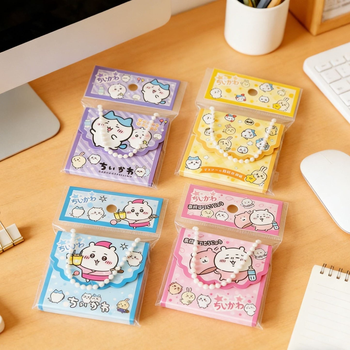 StationeryHaul Chiikawa pearl chain tote bag style memo pads in purple, yellow, blue, and pink on a wooden desk.