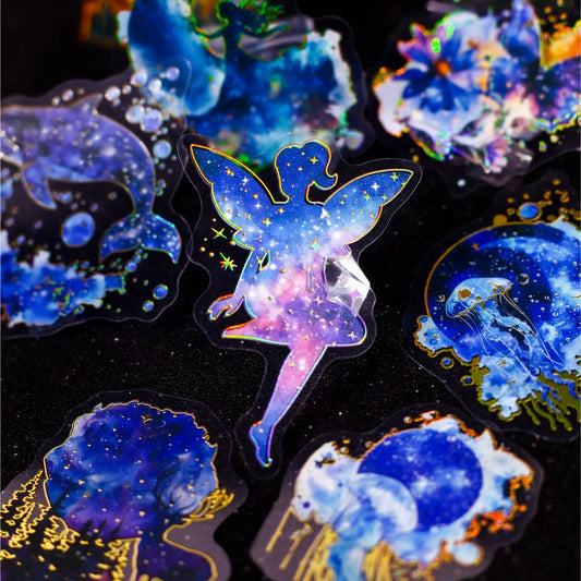 StationeryHaul holographic fairy sticker with galaxy design in blue, purple, and gold. Transparent material.