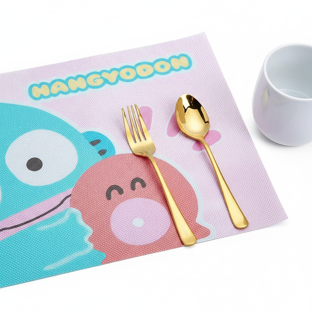 StationeryHaul Hangyodon placemat with blue and pink characters, gold fork and spoon on pink background.