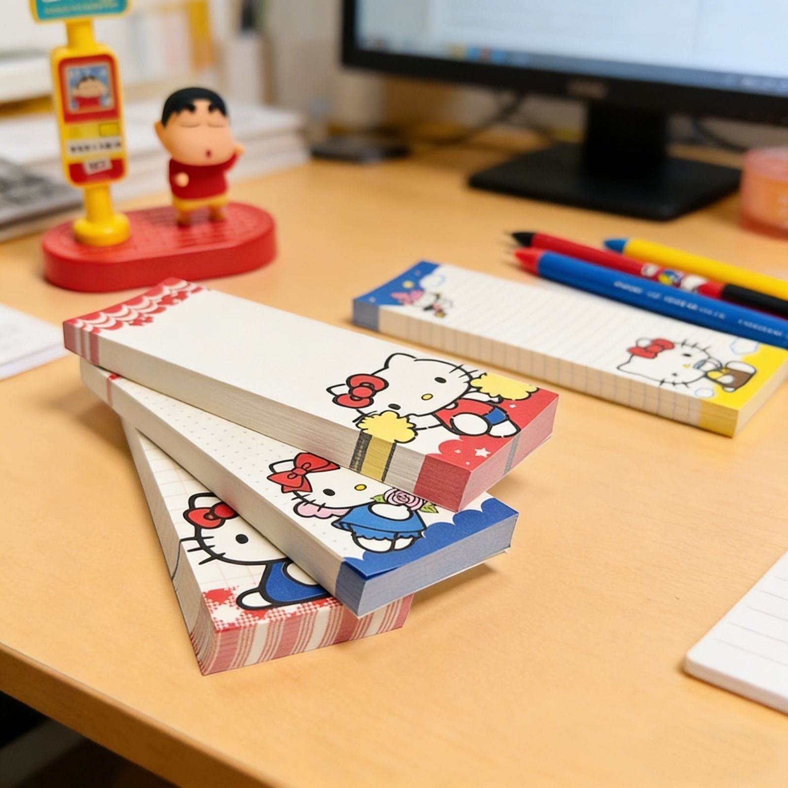 StationeryHaul Hello Kitty long memo notebooks with colorful character illustrations on a wooden desk