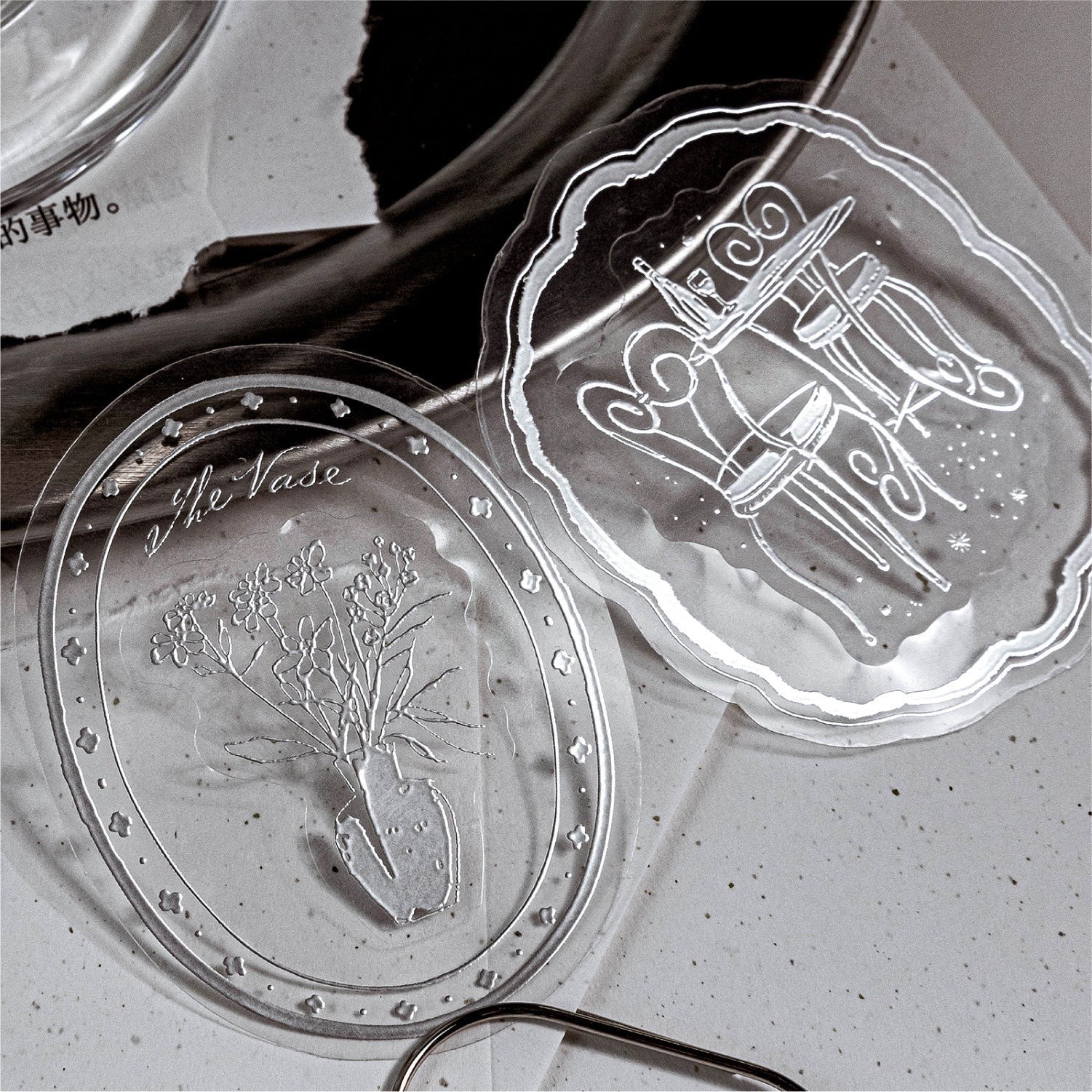 StationeryHaul iridescent clear stickers featuring a vase with flowers and a table with chairs design.