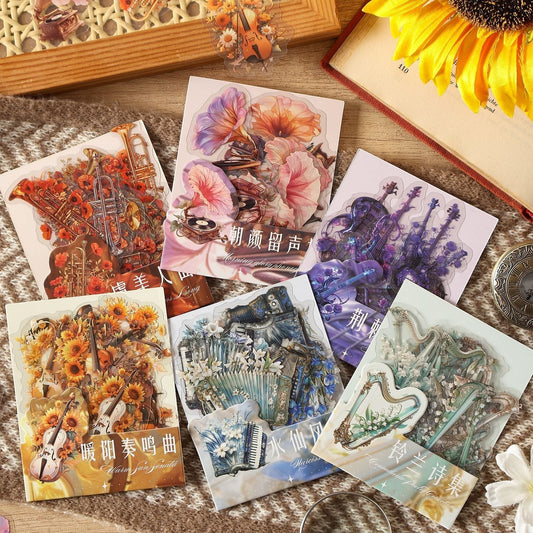 StationeryHaul Musical Instruments and Floral Decorative Sticker Set featuring violins, harps, accordions, and brass instruments with vibrant floral motifs. Transparent material.