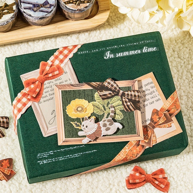 StationeryHaul decorative craft ribbon with orange and brown plaid bows on a green gift box with cat and flower art
