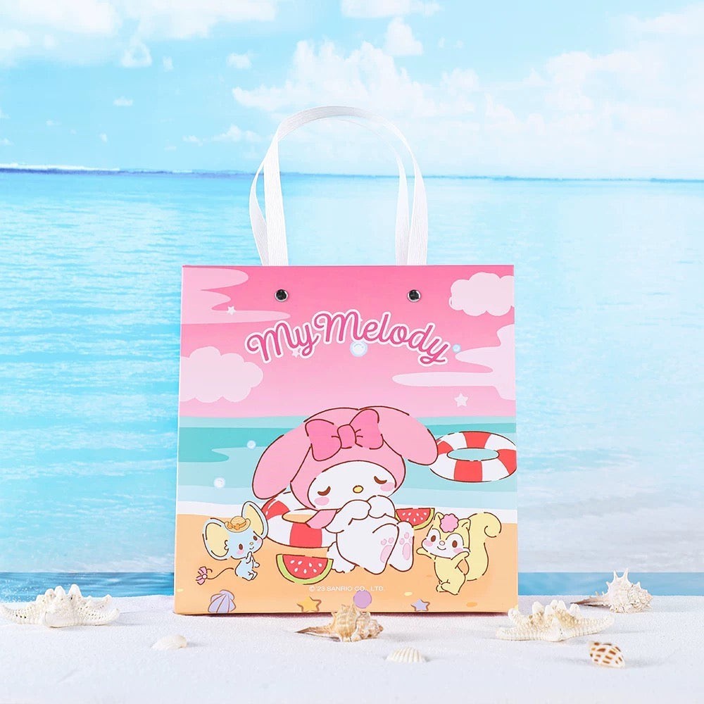 StationeryHaul Sanrio Characters gift bag featuring My Melody sleeping on a beach with watermelon slices and friends. Pink paper bag with white handles.