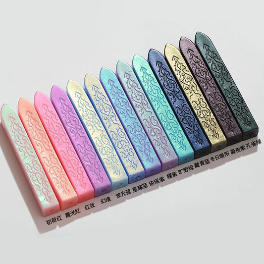 StationeryHaul collection of 11 iridescent sealing wax sticks in pastel and jewel tones with ornate embossed patterns.