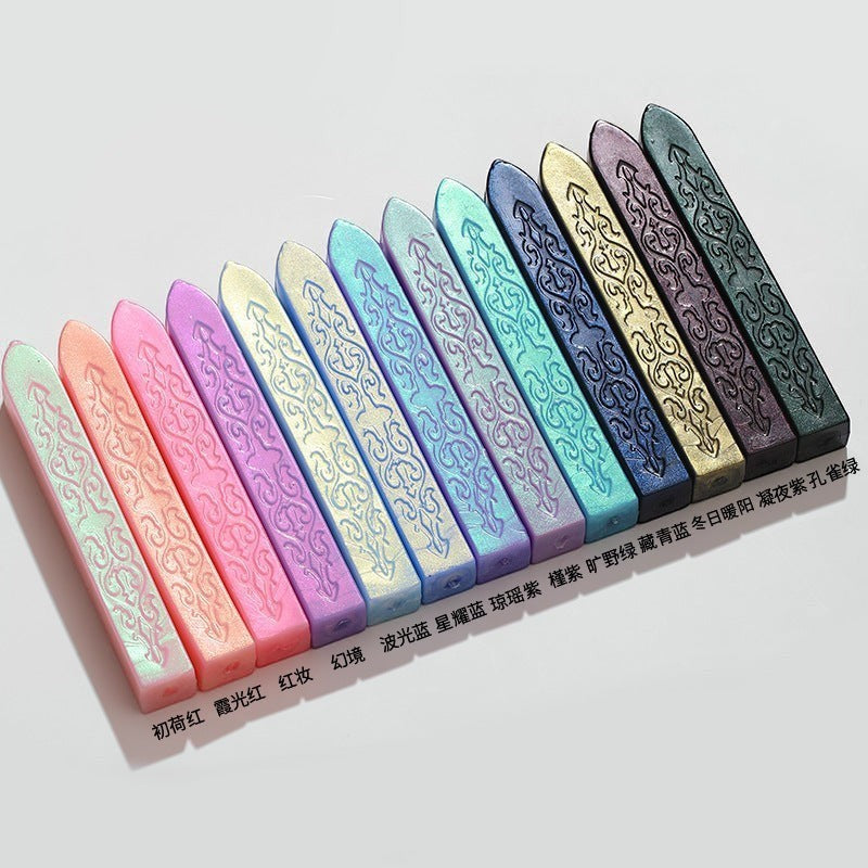 StationeryHaul collection of 11 iridescent sealing wax sticks in pastel and jewel tones with ornate embossed patterns.