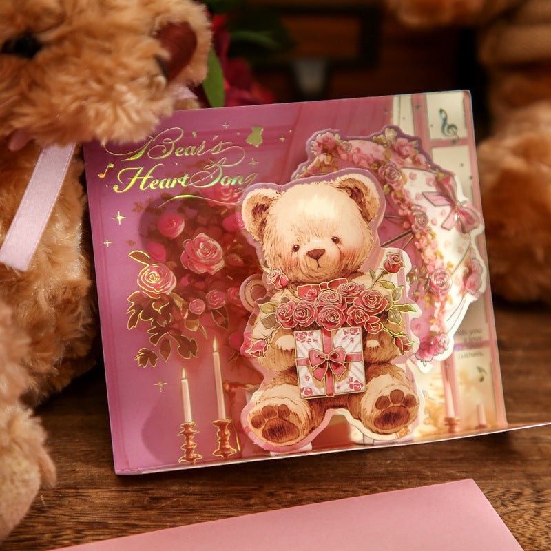 StationeryHaul pop-up card featuring a teddy bear holding roses and a gift, with candles and floral accents.