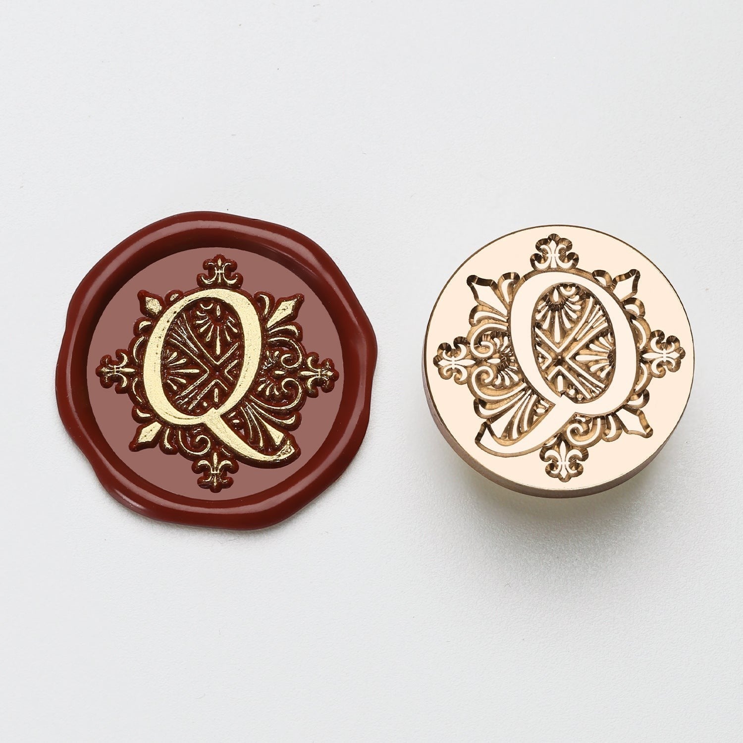 StationeryHaul elegant letter Q wax seal stamp with ornate detailing on burgundy wax and gold metal.