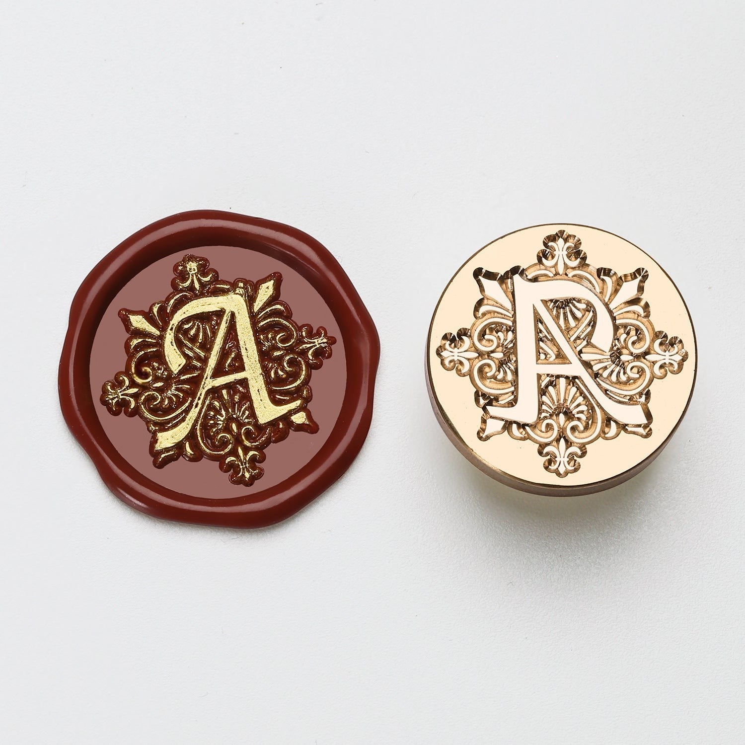 StationeryHaul elegant brass wax seal stamp with ornate letter A design, next to a burgundy wax impression.